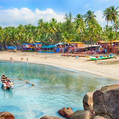 Beautiful Goa province beach in India with fishing boats and stones in the sea